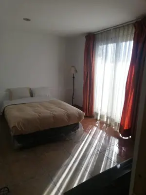 a bedroom with a bed and a window with curtains at CasaHotel Centro - Huancayo in Huancayo