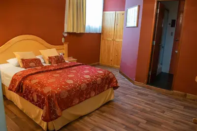 a bedroom with a bed with a red blanket at Hotel Inka Path in Lima