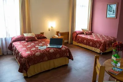 a hotel room with two beds and a laptop on the bed at Hotel Inka Path in Lima