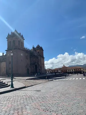 a large building with a clock tower in a plaza at Qolqampata Hotel in Cusco