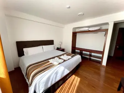 a bedroom with a bed with white flowers on it at Hotel Andes Urubamba in Urubamba