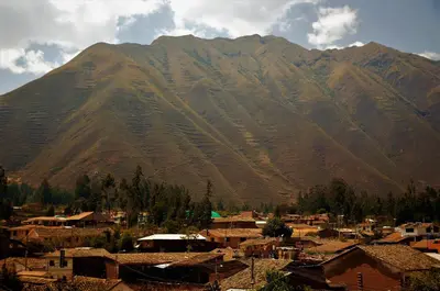 a village in front of a large mountain at Hotel Andes Urubamba in Urubamba