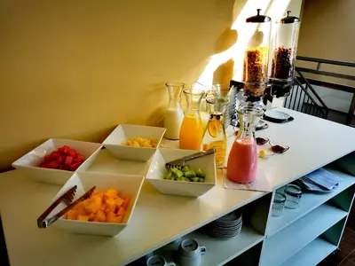 a table topped with bowls of fruits and juice at Hotel Andes Urubamba in Urubamba