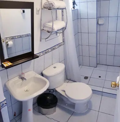 a small bathroom with a toilet and a sink at Cusco de mis Sueños in Cusco