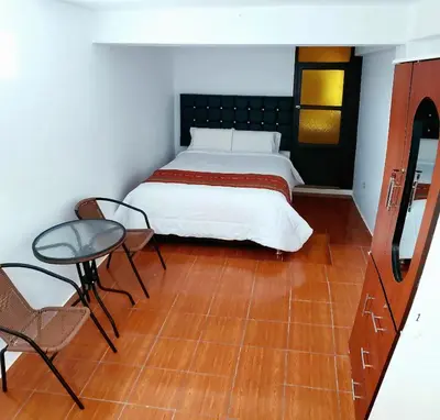 a bedroom with a bed and a table and chairs at Cusco de mis Sueños in Cusco