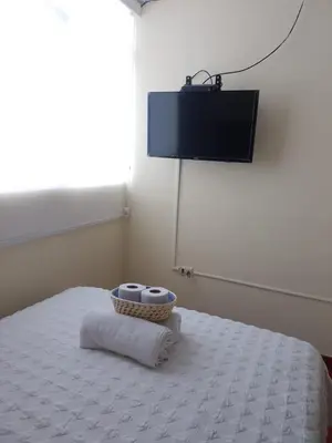 a room with a bed with a television on the wall at Runawasi Caribe, Lima centric 2BDR, 20 min from airport in Lima