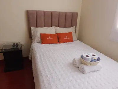 a bed with two pillows and a basket of towels at Runawasi Caribe, Lima centric 2BDR, 20 min from airport in Lima