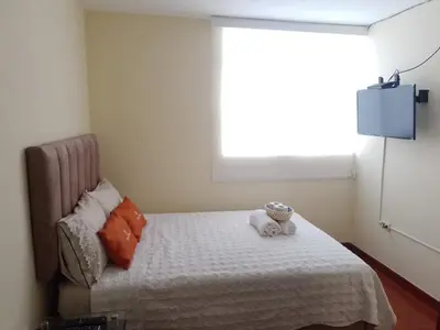 a bedroom with a bed with a stuffed animal on it at Runawasi Caribe, Lima centric 2BDR, 20 min from airport in Lima