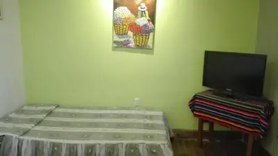 a room with a bed and a flat screen tv at Posada Junco y Capuli in Huancayo
