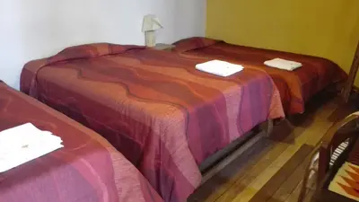 two beds sitting next to each other in a room at Posada Junco y Capuli in Huancayo