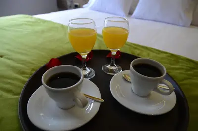 a tray with two cups of coffee and two glasses of orange juice at Hotel Monte Cafeto INN in Pichanaki