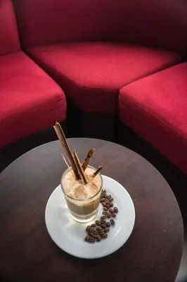 a cup of coffee on a table with coffee beans at Hotel Monte Cafeto INN in Pichanaki