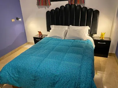 a bedroom with a large bed with a blue comforter at BROTHERs HOUSE in Cusco