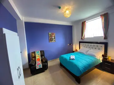 a blue bedroom with a bed and a chair at BROTHERs HOUSE in Cusco