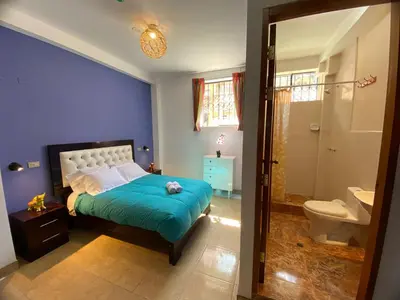 a blue bedroom with a bed and a bathroom at BROTHERs HOUSE in Cusco