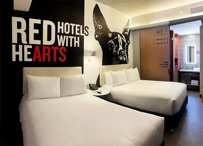 two beds in a hotel room with red hotels with hisarts sign at Radisson RED Miraflores in Lima