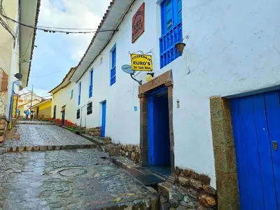 an alley with blue doors on a white building at Hospedaje Euro's De San Blas in Cusco