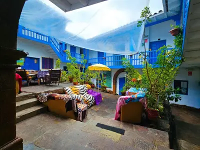 a patio with couches and tables in a building at Hospedaje Euro's De San Blas in Cusco