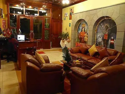 a living room with leather couches and a piano at Hotel Inkayra in Cusco