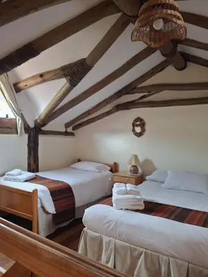 two beds in a room with wooden ceilings at Casona La Recoleta in Cusco