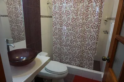a bathroom with a sink and a toilet and a shower at Hostal Camiluz in Nazca