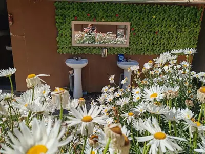 a bathroom with two sinks and white flowers at Soraypampa Hostel - Private Cabins & Dorms for Self-Guided Humantay & Salkantay Trek -Comidas-hot shower-wifi-Pack horses in Salcantay