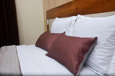 a bed with white sheets and pillows at Martinika in Lima
