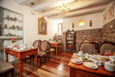 a dining room with tables and chairs and a stone wall at Casona Corrales Hotel Boutique in Cusco