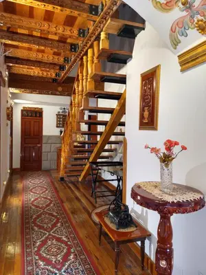 a living room with wooden stairs and a vase on a table at Casona Corrales Hotel Boutique in Cusco