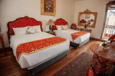 a bedroom with two beds with red headboards at Casona Corrales Hotel Boutique in Cusco