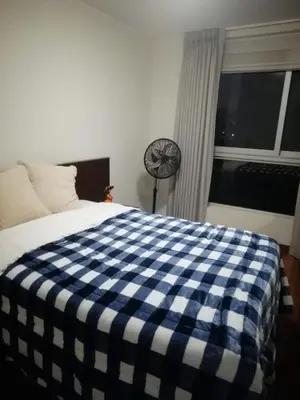 a bedroom with a blue and white checkered blanket on a bed at Hope San Isidro in Lima