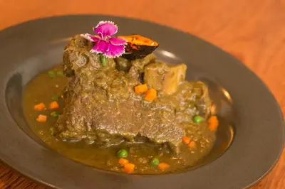 a plate of food with meat and vegetables and a flower at Hotel Britania Crystal Collection in Lima