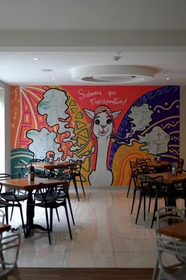 a restaurant with tables and a mural on the wall at Hotel Britania Crystal Collection in Lima