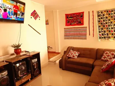 a living room with a couch and a tv at Marlon's House Nasca in Nazca