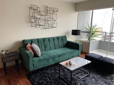 a living room with a green couch and a table at MLA Apartments - Alcanfores in Lima