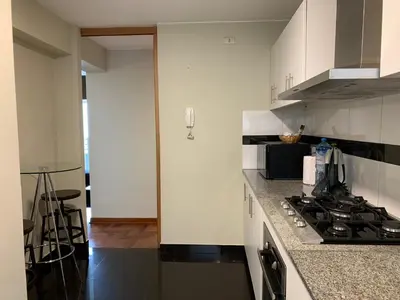 a kitchen with white cabinets and a stove top oven at MLA Apartments - Alcanfores in Lima