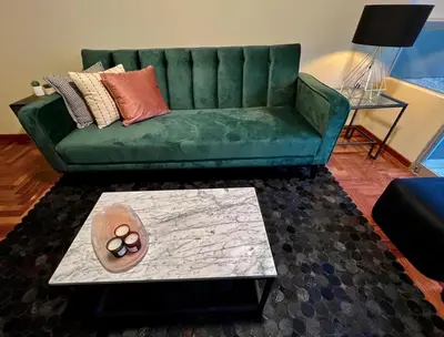 a green couch in a living room with a table at MLA Apartments - Alcanfores in Lima