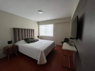 a bedroom with a bed and a television in it at MLA Apartments - Alcanfores in Lima