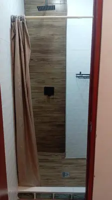 a shower with a glass door in a bathroom at Chakana Family Home Lima Airport in Lima