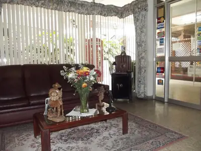 a living room with a couch and a vase of flowers on a table at Hostal Gemina in Lima
