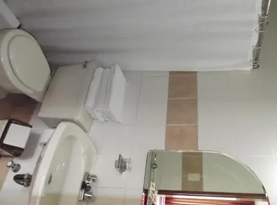 a bathroom with a toilet and a sink at Hostal Gemina in Lima
