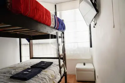 a bedroom with two bunk beds and a window at Pet Friendly Apart-Maximo 9 Personas-Piscina-Parrilla-Billar-Gimnasio in Lima