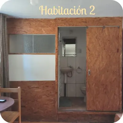 a bathroom with a toilet and a glass door at Munay San Blas Wasi in Cusco