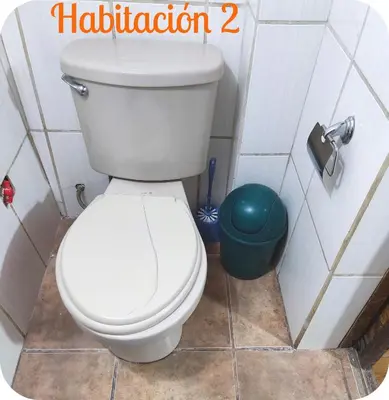 a bathroom with a white toilet and a trash can at Munay San Blas Wasi in Cusco