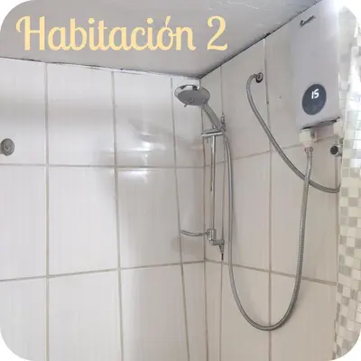 a shower in a white tiled bathroom with the word at Munay San Blas Wasi in Cusco