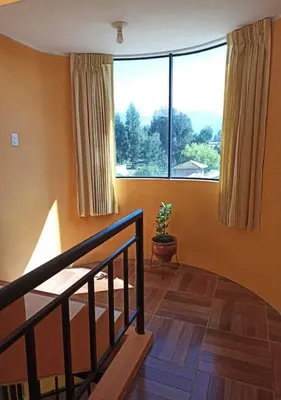 a room with a staircase and a large window at La Azotea in Huancayo