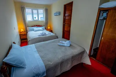 a hotel room with two beds and a mirror at Hostal El Peregrino in Cusco