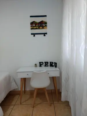 a white desk with a chair and a picture on the wall at HABITACIÓN ALBORADA 1 con baño privado in Lima
