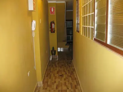 a hallway with yellow walls and a fire hydrant at Posada Gino in Pisco
