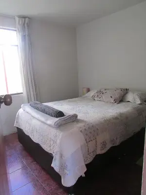 a bedroom with a bed and a window at MUNAYCHA`S WASI in Cusco